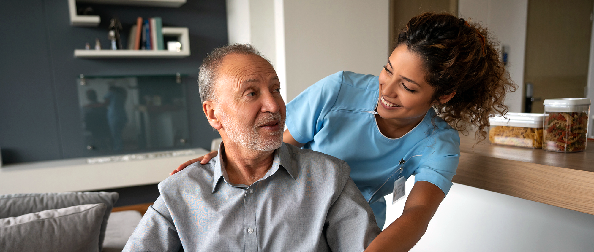 home care nurse smiling with patient in wheelchair